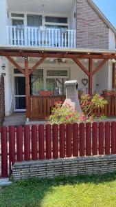 uma cerca vermelha em frente a uma casa em Edina-ház em Balatonboglár