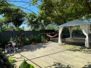 a gazebo with a bench and a hammock in a backyard at Hotel Liza in Batumi