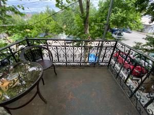d'un balcon avec une table et une balustrade en fer forgé. dans l'établissement Hotel Shalimar, à Tbilissi