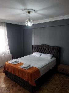 ein Schlafzimmer mit einem Bett mit einer orangefarbenen Decke in der Unterkunft Mardy Deluxe Houses in Istanbul