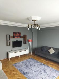 ein Wohnzimmer mit einem Sofa und einem Flachbild-TV in der Unterkunft Mardy Deluxe Houses in Istanbul
