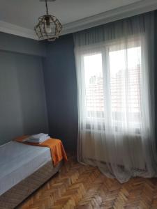 een slaapkamer met een bed en een groot raam bij Mardy Deluxe Houses in Istanbul