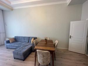 Caspian Pearl Residence في سومقاييت: غرفة معيشة مع أريكة زرقاء وطاولة