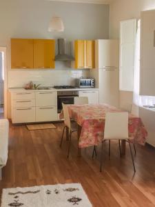 cocina con mesa, sillas y armarios amarillos en Villa Viola en Forlì