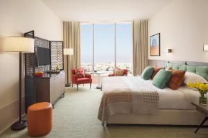 a hotel room with a large bed and a television at Assila, a Luxury Collection Hotel, Jeddah in Jeddah