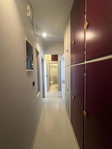 a corridor of a hallway with white walls and purple doors at Athens Central Apartment in Athens