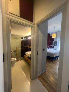 a bathroom with a toilet and a bedroom with a bed at Athens Central Apartment in Athens