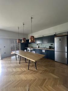 una gran cocina con una mesa de madera en una habitación en Athens Central Apartment, en Atenas