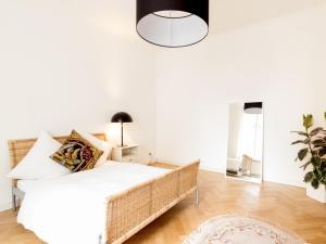 um quarto branco com uma cama e um vaso de plantas em Ferienwohnung in Altstadtnähe em Weimar