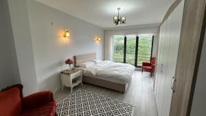 Un dormitorio blanco con una cama y una ventana. en Greenplain Smurf, en Trabzon