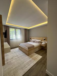 a bedroom with a large bed and a large window at Bimola Rezidans in Uzungöl