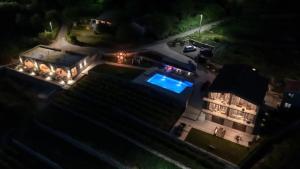 an aerial view of a house at night with a swimming pool at Apartments and Winery Djukovic in Virpazar