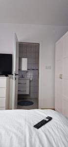 a remote control sitting on top of a bed at Apartment & Rooms Majetic-Draskovic in Bizovac +14 photos