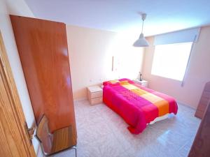 1 dormitorio con 1 cama con una manta colorida en Ajo Playa homes 1 en Bareyo