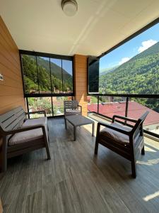 a room with two benches and a large window at Bimola Rezidans in Uzungöl