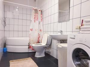 a bathroom with a toilet and a sink and a washing machine at Riga Centre Sun Apartments in Rīga +53 photos