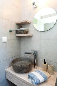 y baño con lavabo de piedra y espejo. en ANCIENT MEROPIA - Les jardins des muses en Apollonía