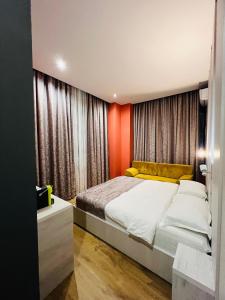 a bedroom with a large bed with an orange wall at Colombia Apartments&Rooms in Durrës