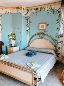 1 dormitorio con 1 cama grande y paredes azules en Alexander's Home, en Collecorvino