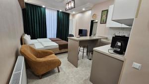 MD Apart Hotel Tbilisi في تبليسي: غرفة مع سرير ومطبخ مع مكتب
