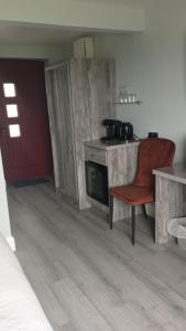 a kitchen with a stove and a red chair at Tiernan's Luxury King Room Ensuite in Newtown-Dillon