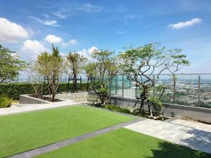 an artificial lawn in the backyard of a house at Two bedroom condo with rooftop pool in Ban Talat Rangsit