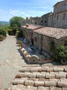 un antiguo edificio de piedra con un patio delante de él en Borgo Cerbaiola en Montecastelli Pisano