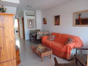 sala de estar con sofá naranja y mesa en AS019 2-Bedroom Casa Calypso - in Calas del Pinar, en San Juan de los Terreros