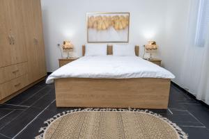 a bedroom with a large bed and a rug at צימר בכפר - סוויטות ובקתות מקסימות עם בריכה במתחם ונוף מהמם in Rama