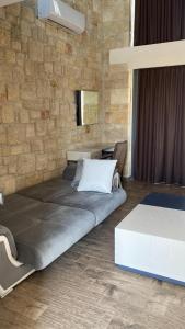 a bedroom with two beds and a brick wall at Sunshine Villa: Getaway in Kallithea in Kallithea Halkidikis +17 photos