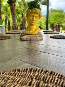 a statue of a head on a table with palm trees at Baglio Mazzara in Custonaci