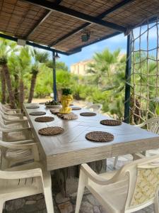 a wooden table and chairs on a patio at Baglio Mazzara in Custonaci