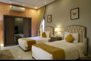a hotel room with two beds and a mirror at Tamara Beach Resort, Al Khobar Half Moon Bay-"Families Only" in Half Moon Bay +57 photos