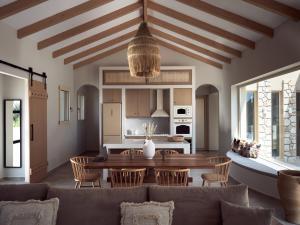 a kitchen and living room with a table and chairs at Uvetta Villa in Makhairádhon