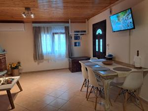 a dining room with a table and a tv on the wall at SUNNY STUDIO in Skala Marion