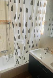 bagno con lavandino e tenda doccia di Anemos Apartment a Keramotí