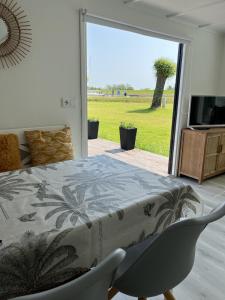a bedroom with a bed and a sliding glass door at Chalet S1 in Workum bij strand en IJsselmeer in Workum