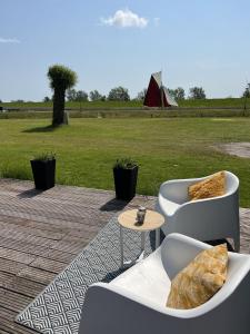 een patio met 2 banken, een tafel en een veld bij Chalet S1 in Workum bij strand en IJsselmeer in Workum