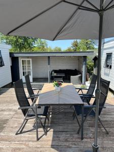 a table and chairs with an umbrella on a deck at Chalet S1 in Workum bij strand en IJsselmeer in Workum