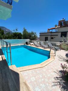 a swimming pool with chairs and a house at ATHERİNA BUTİK OTEL in Kaş