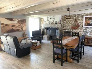 a living room with a table and chairs and a fireplace at Chambres d'Hôtes LES VERGERS DE LOUISE in Thiolières