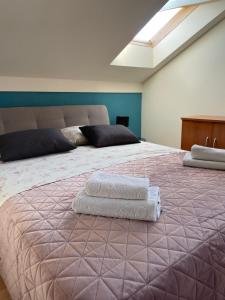 een slaapkamer met een groot bed en 2 handdoeken bij apartment IVA in Supetarska Draga