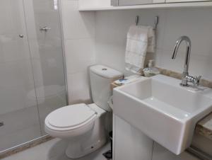 a white bathroom with a toilet and a sink at Barra Pinauna Studio in Salvador +13 photos