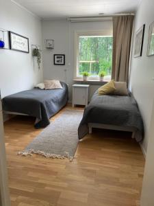 um quarto com 2 camas e uma janela em Rymlig villa med närhet till Tylösand och Halmstad GK em Halmstad