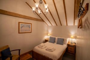 a bedroom with a bed and a chandelier at All Seasons Cottage Breaks in Saxmundham