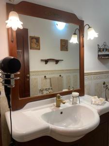 uma casa de banho com um lavatório e um espelho grande em Scala dei Turchi Palace Suites em Realmonte