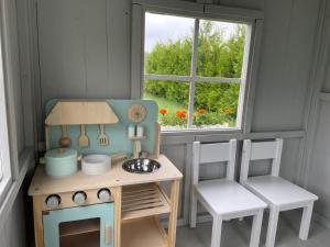 a doll house with a table and a stove and a window at BIAŁE DOMKI in Rusinowo