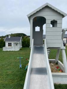 a play house with a slide in a yard at BIAŁE DOMKI in Rusinowo
