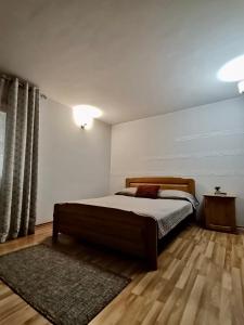 - une chambre avec un grand lit et un tapis dans l'établissement Pensiunea Lu' Movila, à Durau