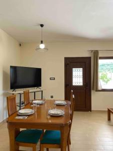 a dining room with a table with chairs and a television at Villa Antonia in Alikanas